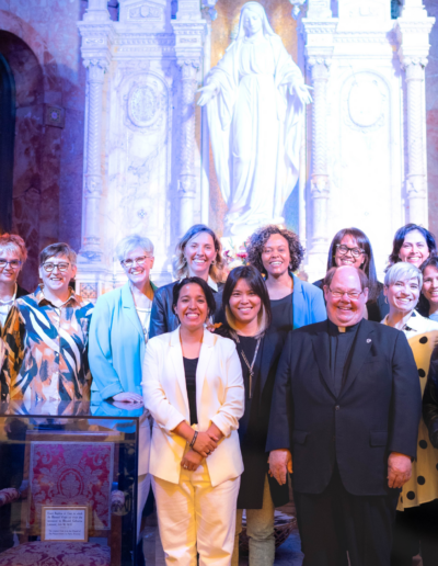 Female vocalists and instrumentalists from the group Gen Verde pose for a photo with Fr. Maher and Fr. Kettelberger in the The Miraculous Medal Shrine.
